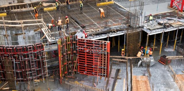 Industrial construction site with workers in high visibility clothing at a steel framework structure., tags: neue der - pexel